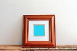 Square wooden picture frame on desk mockup 0WBYPb
