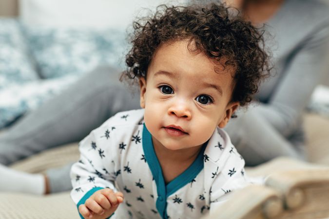 Portrait of cute baby boy with big eyes and curls