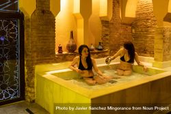 Women sitting in marble bath in Arabic spa 0PeKe5