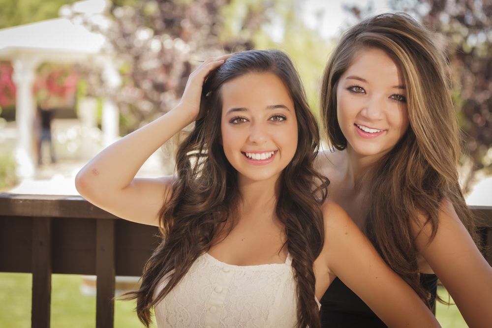 Two smiling female friends in outside garden