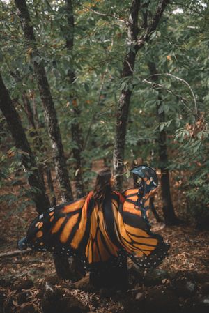 Woman in butterfly costume in forest