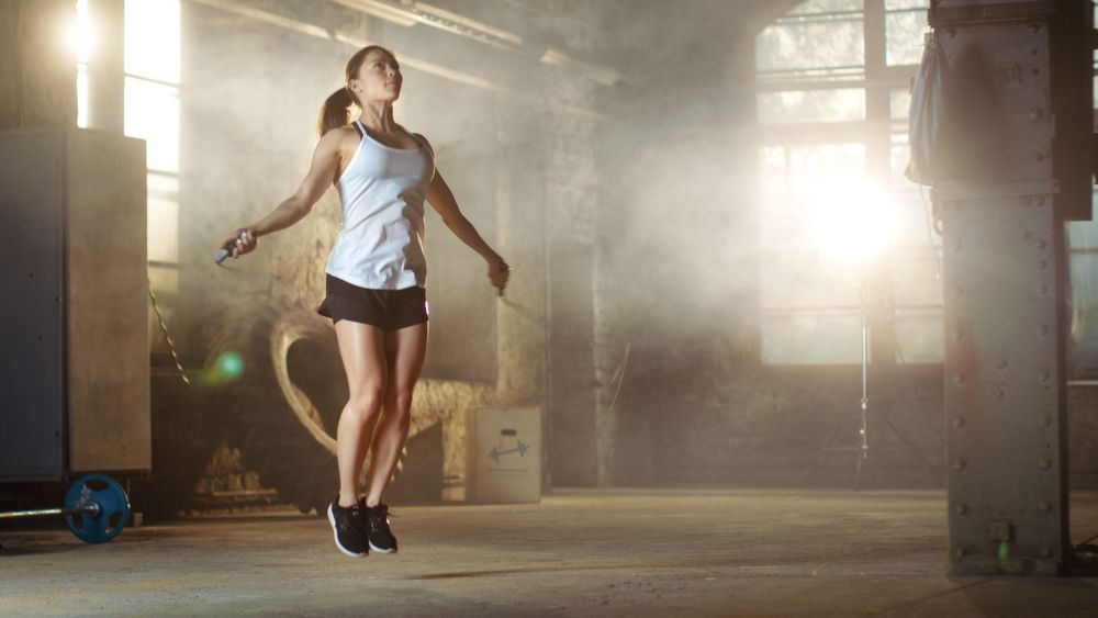 Athletic Woman Exercises with Jump   Skipping Rope in a Gym.