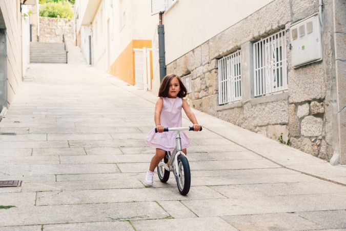Girl riding on bicycle in narrow street