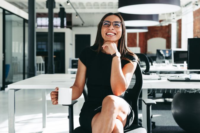 Happy young businesswoman feeling cheerful in a modern office