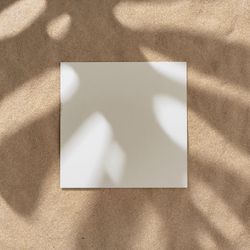 Sand with palm leaf shadows and central square