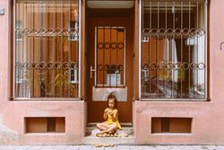 Preschool child sitting with potatoes in doorway