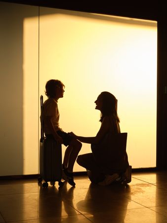 Anonymous woman and boy waiting for flight in airport