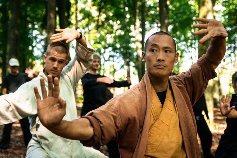 Asian martial arts instructor teaching group in forest