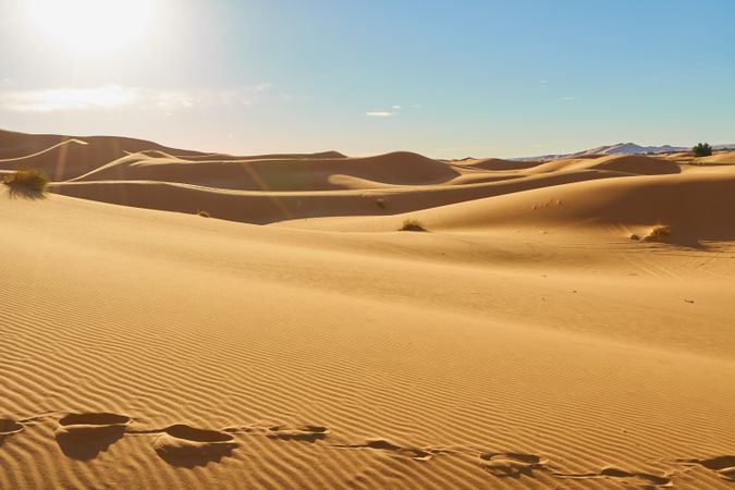 Sand dunes and blue sky with sun