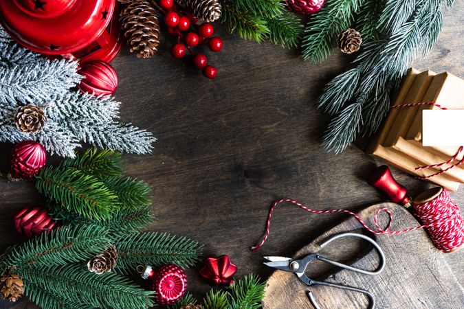 Top view of Christmas setting with pine branches and scissors for giftwrapping on wooden table