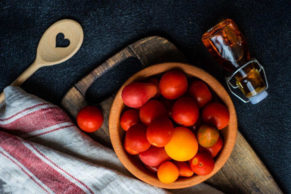 Top view of tomatoes and oil on counter