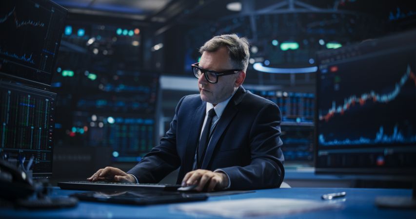 Adult Man in Glasses Looking at Computer Screens, Analyzing Stock Exchange Market Data, Brainstorming a Successful Buying Strategy