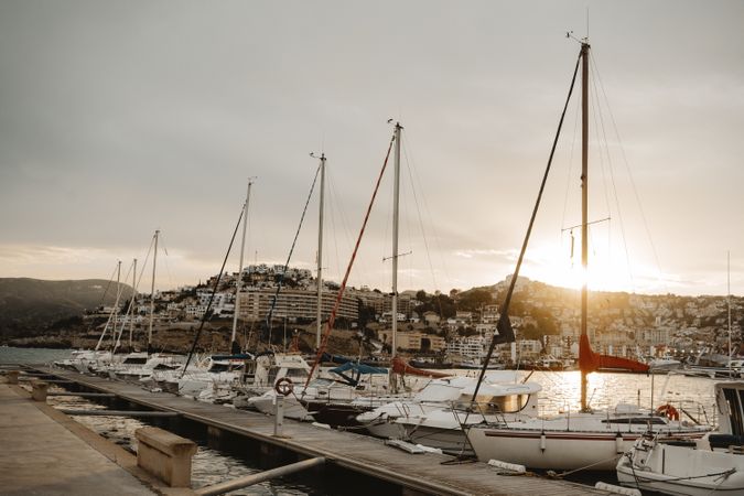 Yachts docked in sea port at sunset