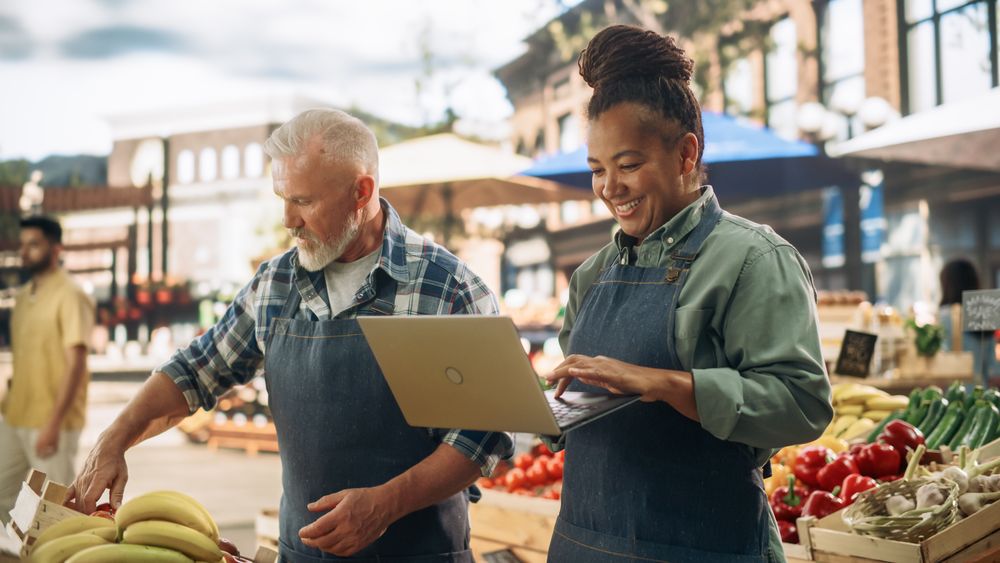 Female and Male Business Partners Managing a Successful Organic Farmers Market Marketplace.