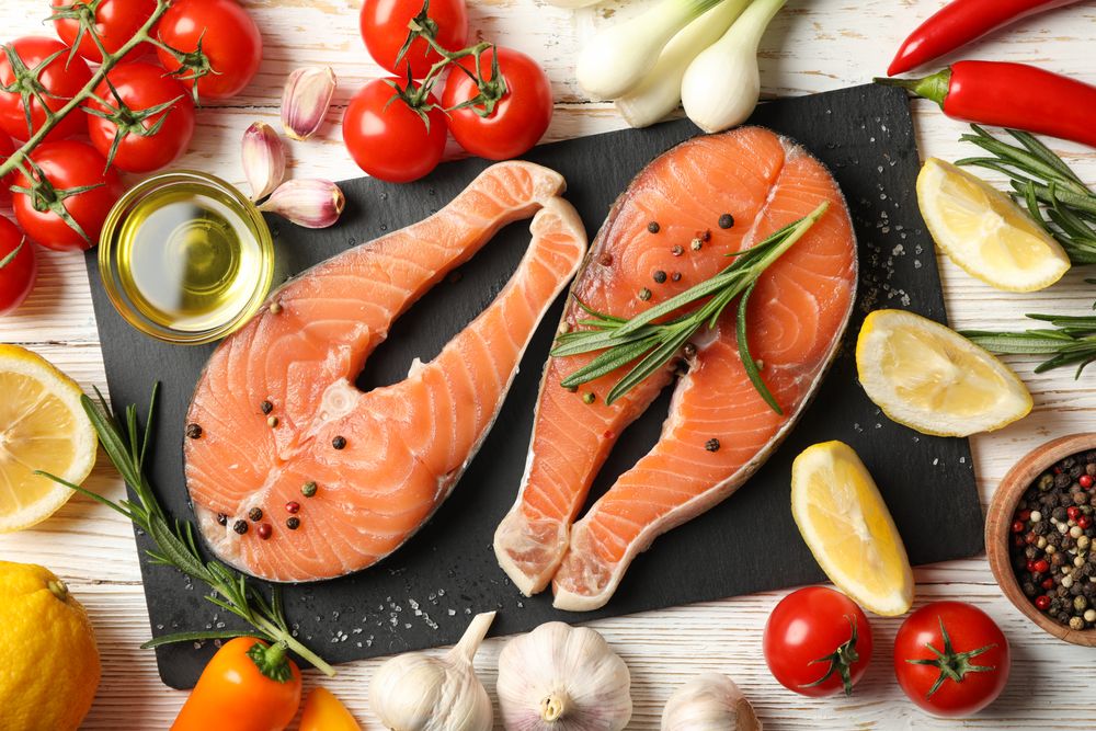 Composition with salmon meat and spices on wooden background, top view
