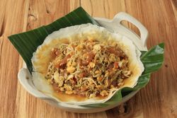 Open lumpia dish served on wooden table