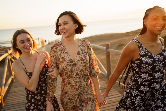 Three laughing woman walking on coastal pedestrian walkway
