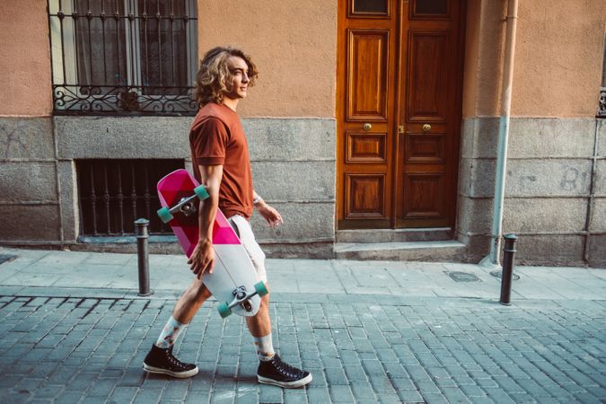 Man carrying longboard on the street