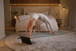 Slim woman doing yoga in Wheel pose at home