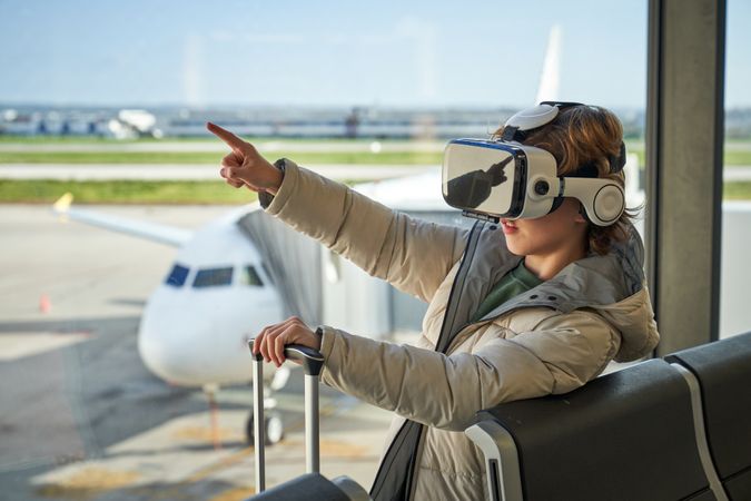 Curious child pointing away while experiencing virtual reality