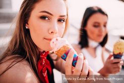 Young woman holding an ice cream cone making eye contact with the viewer K5wXy4