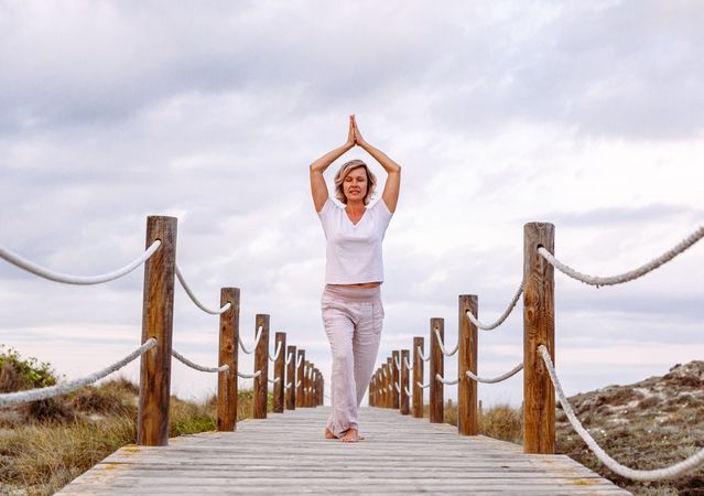 Cheerful woman exercising on timber path