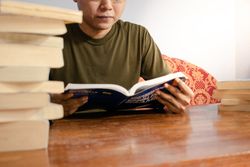 Asian young student study, reading and writing sit on sofa at living room