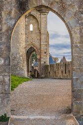 The archway is open to the sky, and the stone building behind it is old