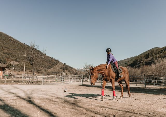 Young woman riding horse on ranch