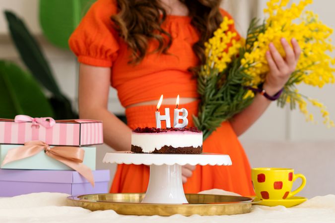 Birthday cake with "HB" candles on a stand, background