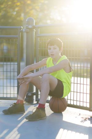 Young basketball player sitting on the court