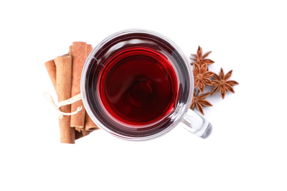 Glass of tasty mulled wine isolated on studio background, top view