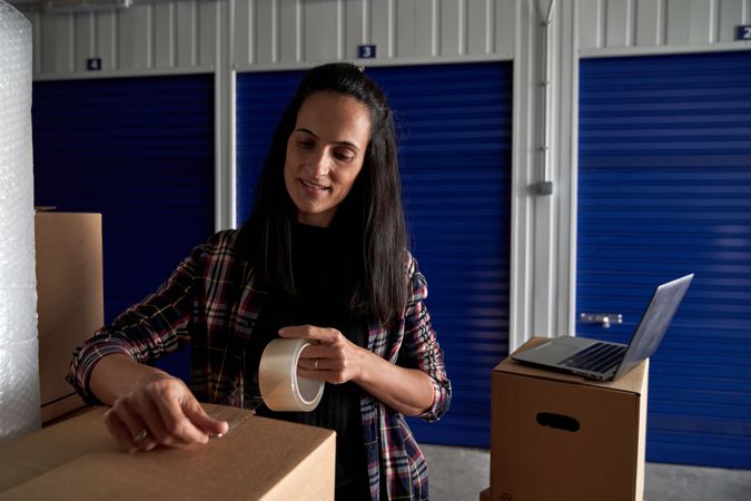 Content woman packing cardboard box