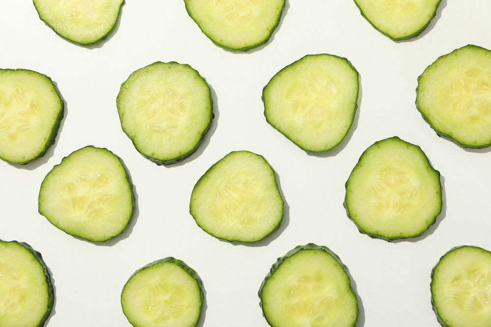 Cucumber slices on blank background, top view
