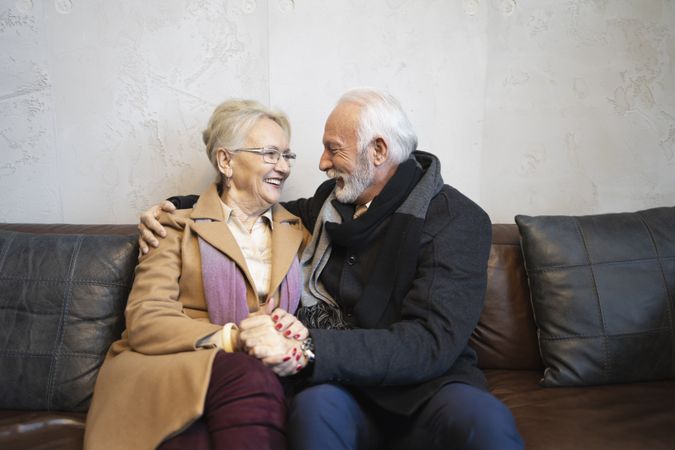Mature couple laughing together on sofa