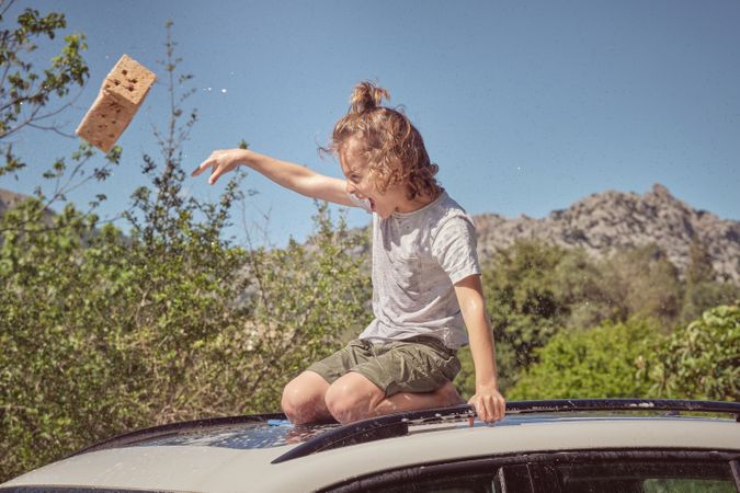 Little boy on car on sunny day