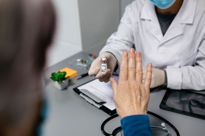 Patient refusing the coronavirus vaccine offered by doctor