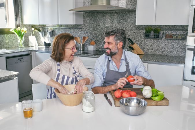 Cheerful couple cooking in kitchen