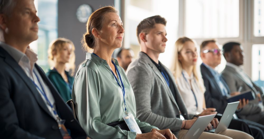 Woman Sitting in Crowded Audience at Business Conference.