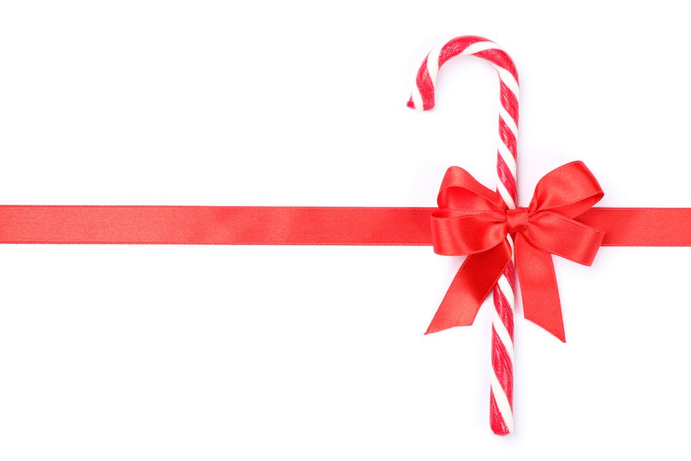 Sweet candy cane with bow isolated on blank background