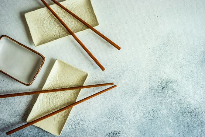 Top view of chopsticks on delicate rectangular ceramic dishes