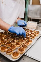 Crop cook decorating pastry with nuts