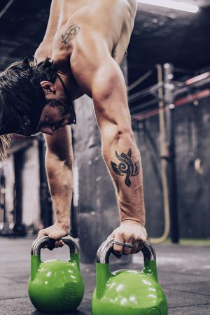 Strong flexible male doing exercise in sport club