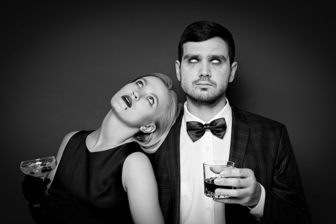 A woman and a man in Halloween costumes on a dark background