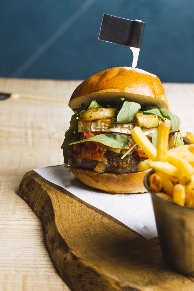 Juicy delicious burger and fried potato on table