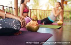 Close up shot of woman sitting at yoga class with coconut 5raZl0