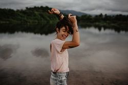 Cheerful woman dancing near lake