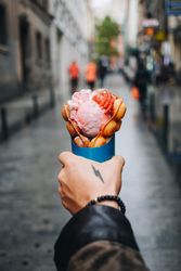Tattooed hand holding waffle and ice cream dessert