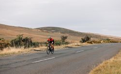 Woman riding on bicycle in in the autumn among the hills