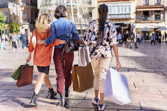 Back of three women walking through shopping area